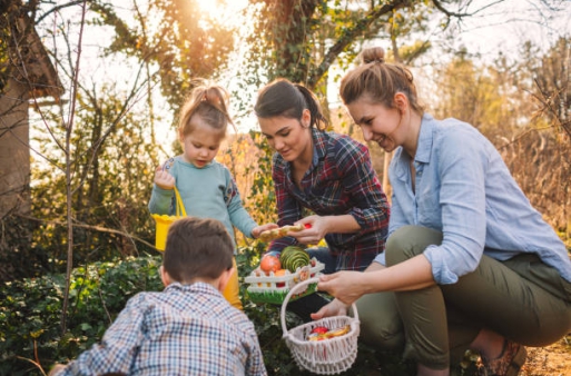 Cute little kids and their moms during Easter egg hunt