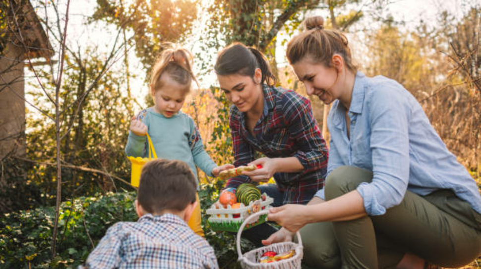 Cute little kids and their moms during Easter egg hunt